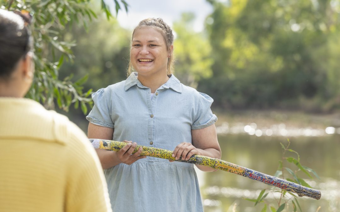 A Ngarrindjeri woman speaks to a visitor about her cultural heritage in the Australian bush.